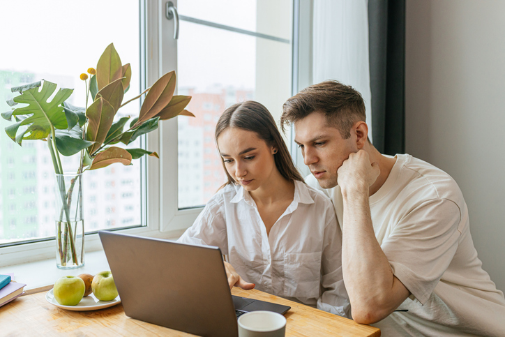 A couple considering the risks of investing in real estate.