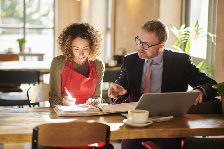 A financial advisor working with a business owner to manage their 401(k) plan.