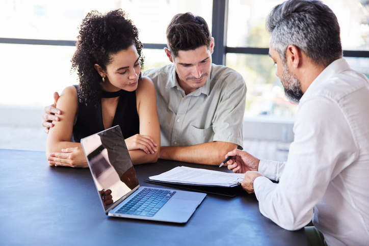 A couple discussing real estate investments with an advisor.