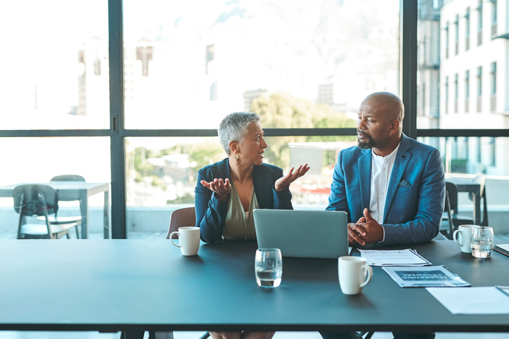 A real estate investor analyzing different rental investments with a financial advisor.