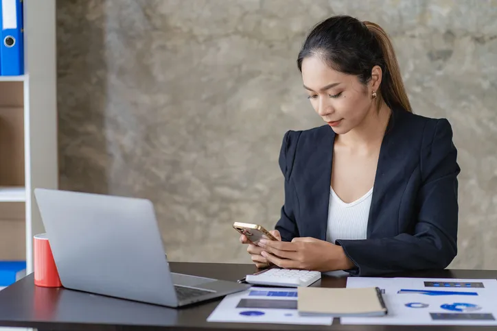 A woman researching and comparing the features of different virtual options trading platforms.