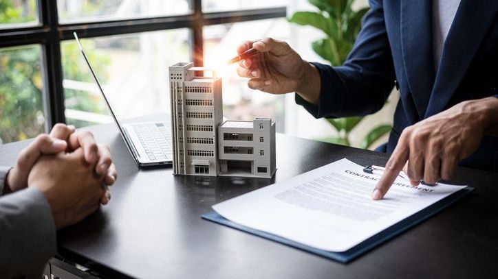 A real estate agent goes over a lease agreement with a business owner who's ready to rent office space .