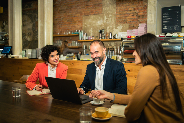 Employees meeting with a financial advisor to discuss 401(k) contribution limits.