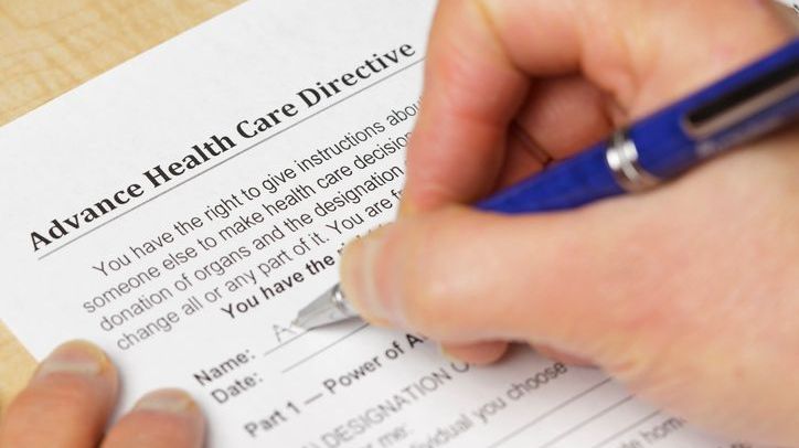 A person signs their advance healthcare directive. 