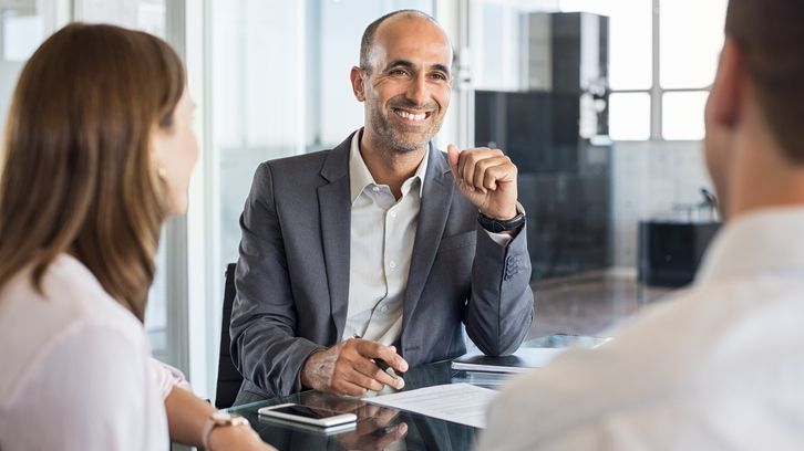 A financial advisor meets with a pair of clients. 