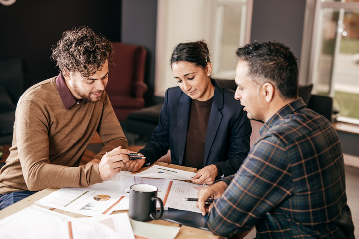 Clients discuss wholesale real estate investments with a financial advisor.