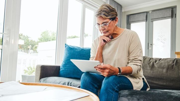 A single woman reviews her will on her tablet.