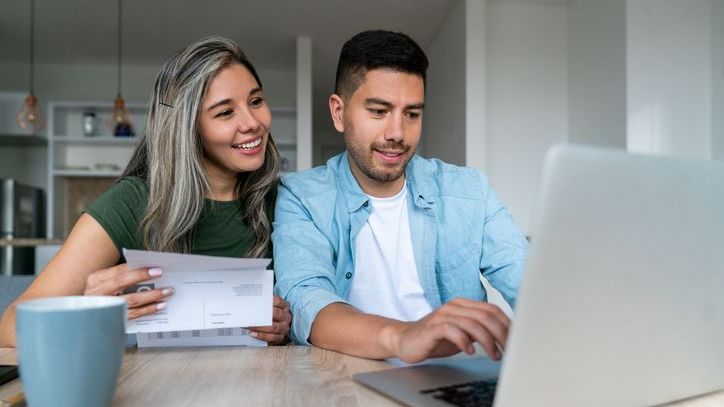 A couple in their early-30s looks over their finances together.