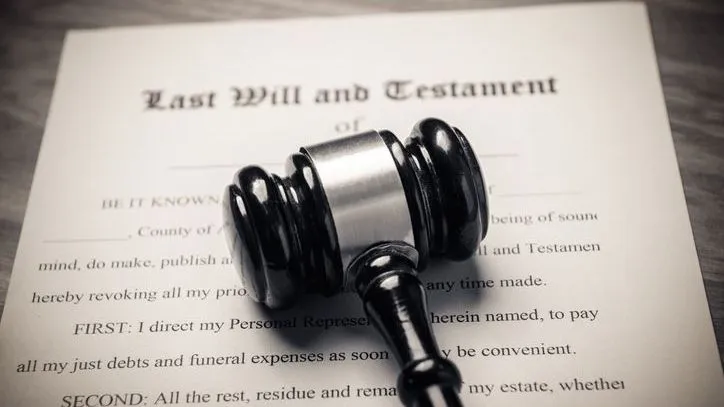 A gavel rests on top of a standard last will and testament form. 