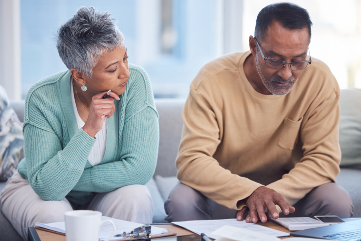 A senior couple discussing how to rebalance their portfolio without selling investments.