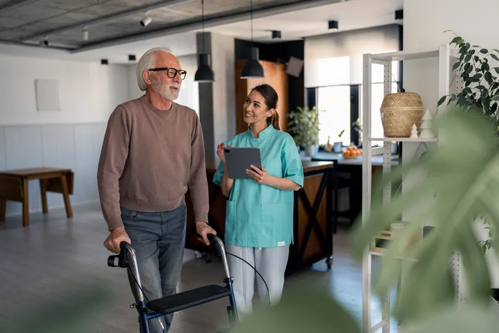 A senior working on his mobility with a caregiver.