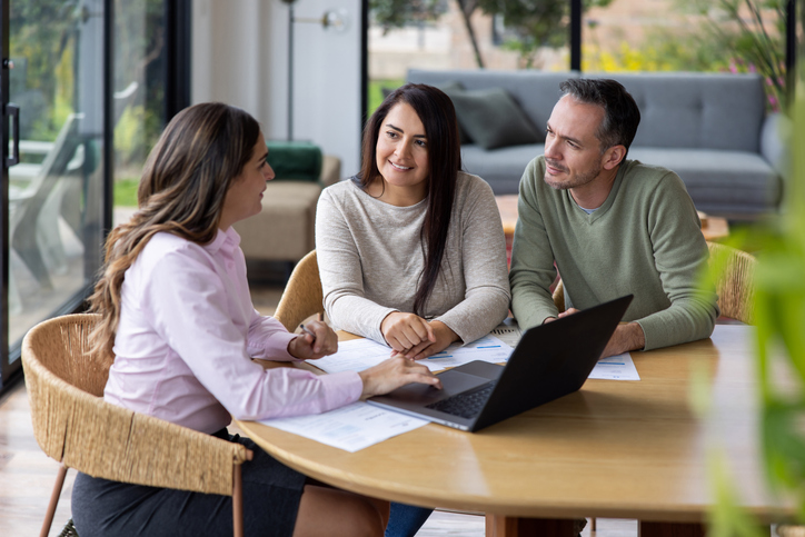 A couple meeting with a financial advisor to discuss tax strategies for their rental income.