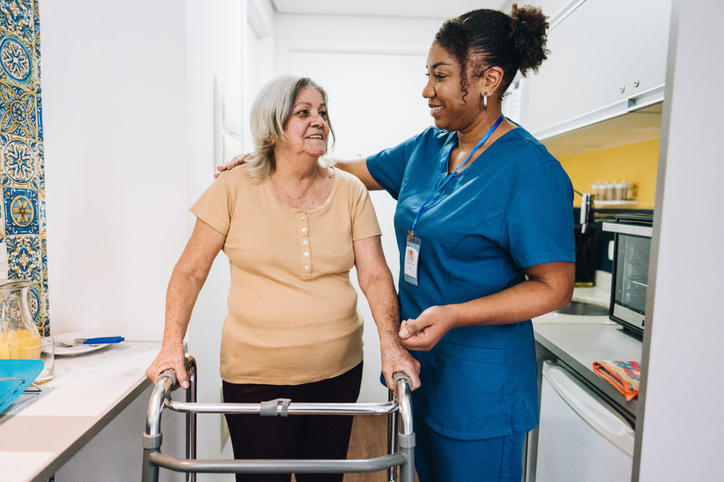 A senior getting help from a caregiver.