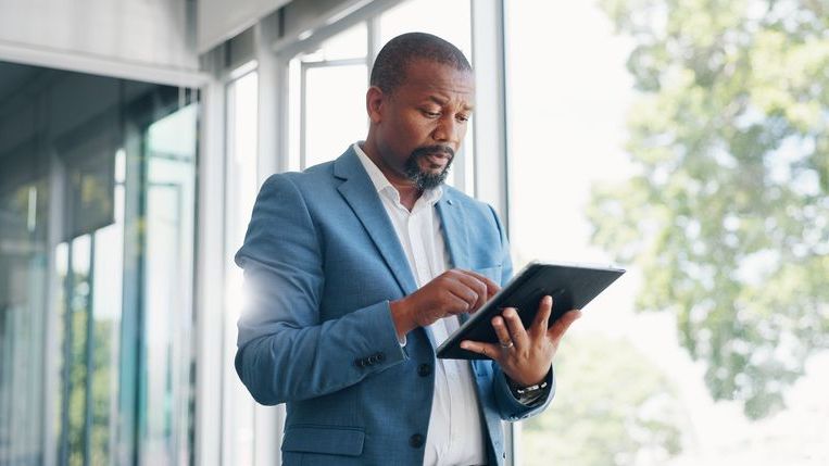 A financial advisor looks up an emerging market fund on his tablet. 