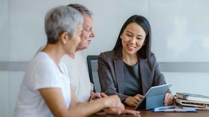 A financial advisor meets with a pair of retired clients. 