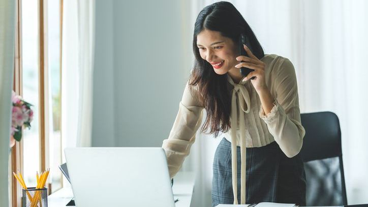 A financial advisor speaks with a client on the phone while looking over their portfolio.