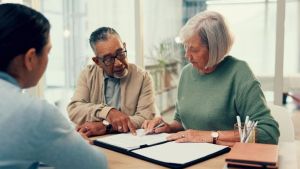 A couple meets with their estate planning attorney to review their will and plans to avoid probate. 