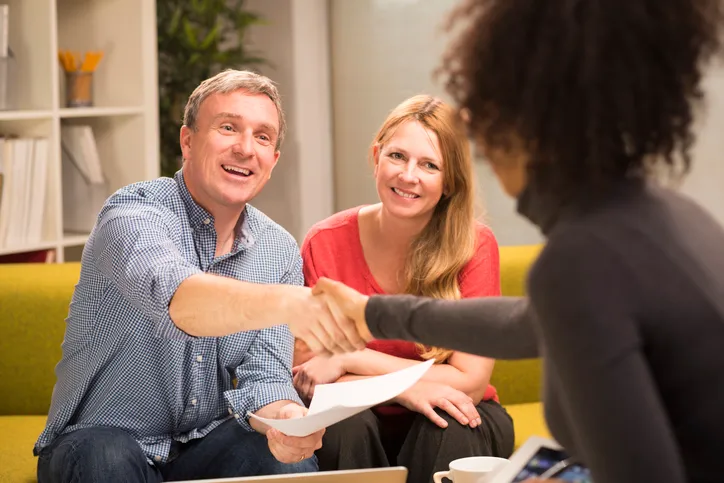 A financial advisor meeting with clients to review a portfolio.