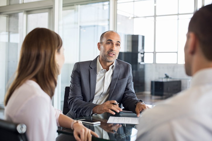 Real estate investors meeting with a financial advisor to review their portfolio.