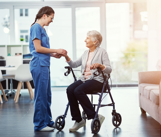 A caregiver speaking with a senior at a long-term care facility.