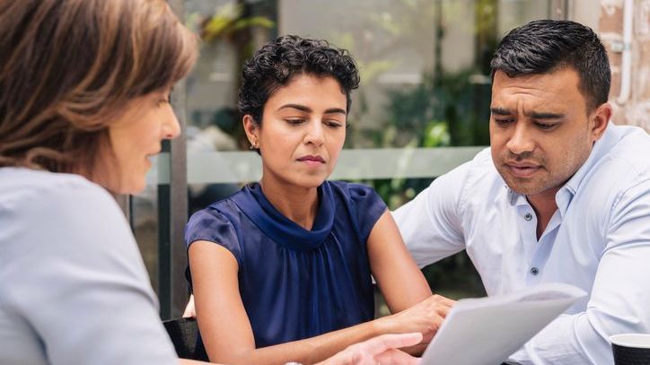 A couple meets with their financial advisor to discuss their portfolio's performance.