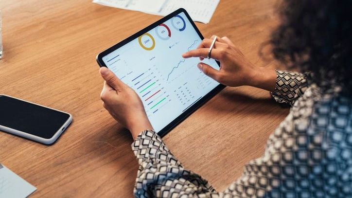 An investor reviews her portfolio on her tablet. 