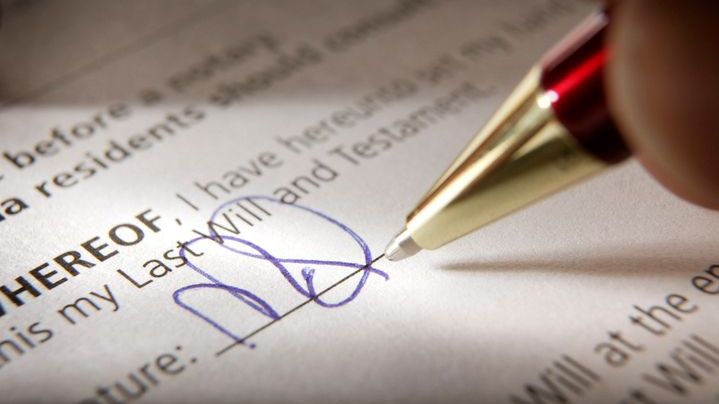 A person signs a codicil to their last will and testament.