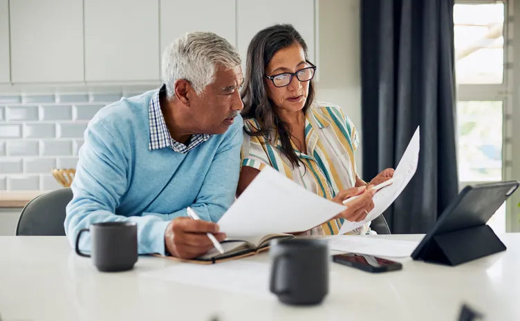 A couple looks over their retirement plan documents. 