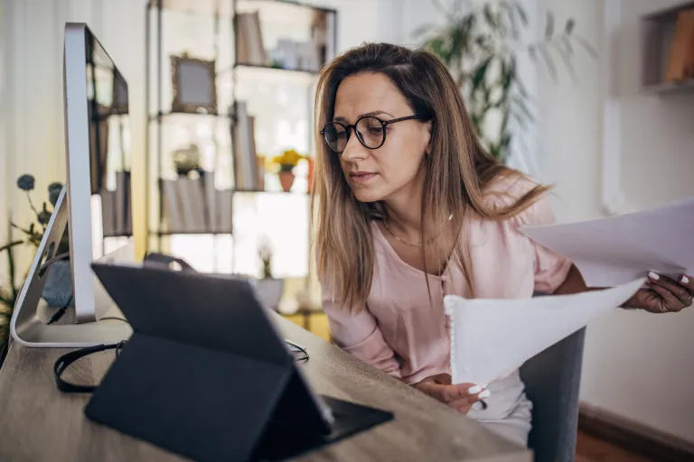 A woman comparing contribution limits for Roth and pre-tax contributions.