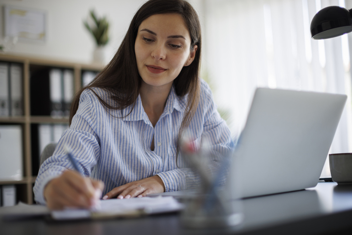 A business owner reviewing her business plan after the government announced potential tariffs.