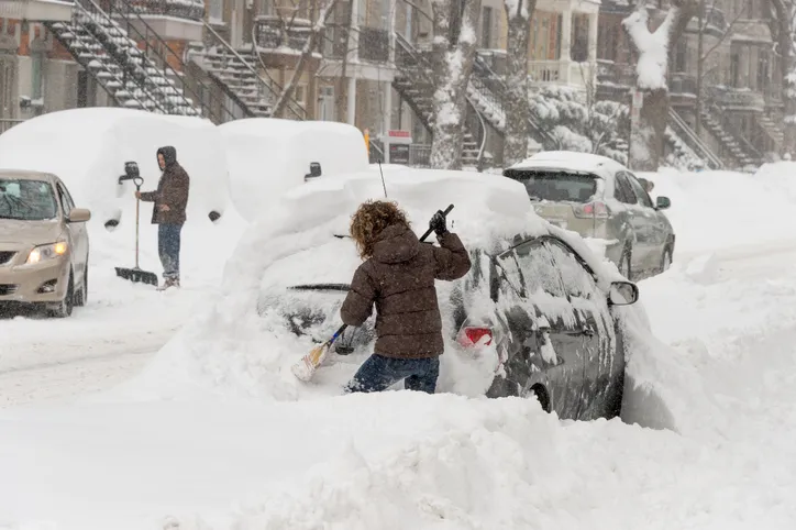 People shovel out their cars after a snowstorm.
