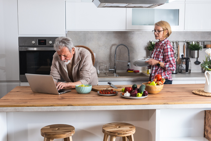 Senior couple cooking dinner together in the kitchen.