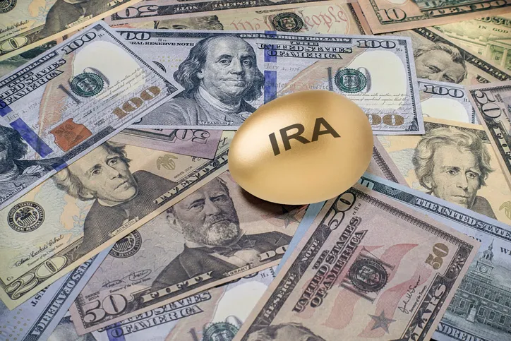 Gold egg labeled "IRA" on a pile of cash.