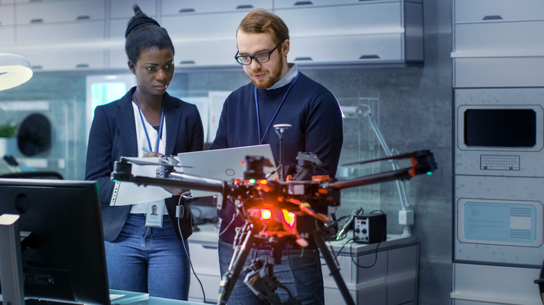 Two engineers working on a drone project in a laboratory.