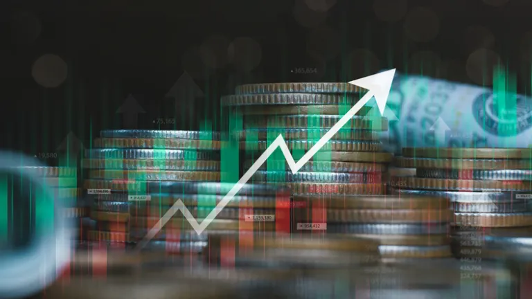 A picture of a stock chart overlaid on a stack of coins.