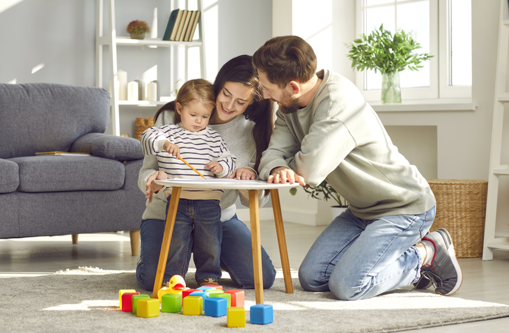 Parents playing with their child at home.