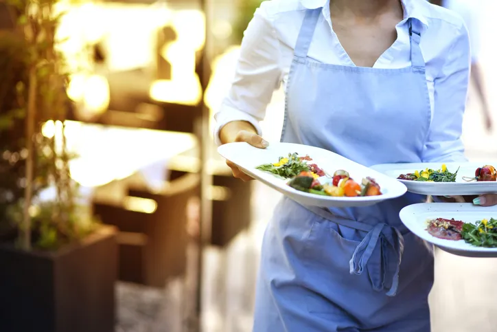 A server carrying dishes at a restaurant.